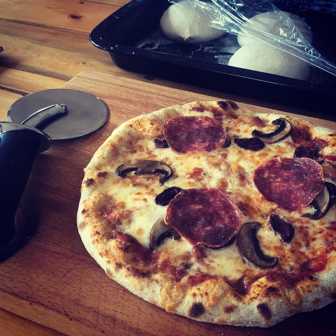 Salami-en-sampioen-pizza met deegballe wat agter rys