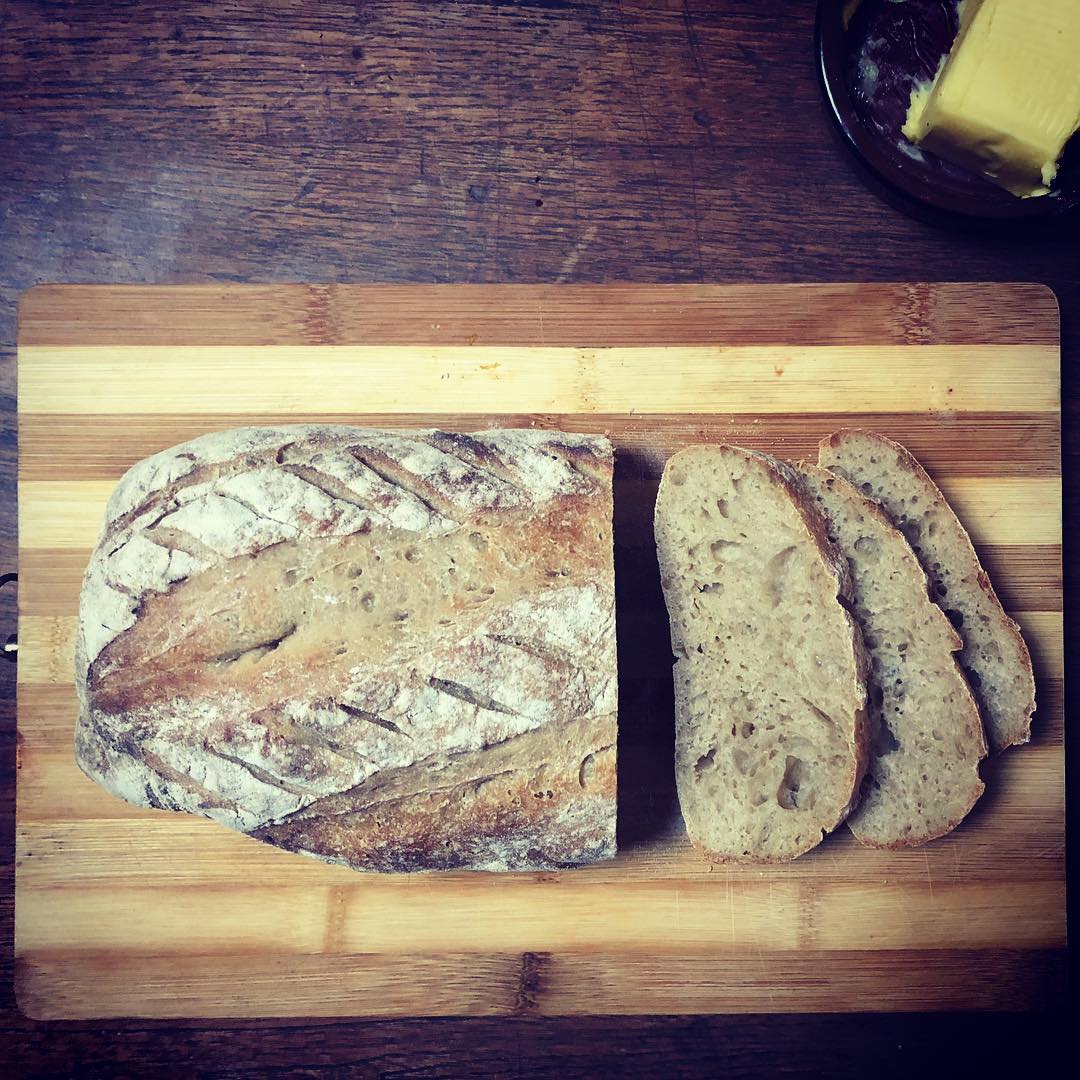Gesnyde brood met botter op 'n bamboesbord